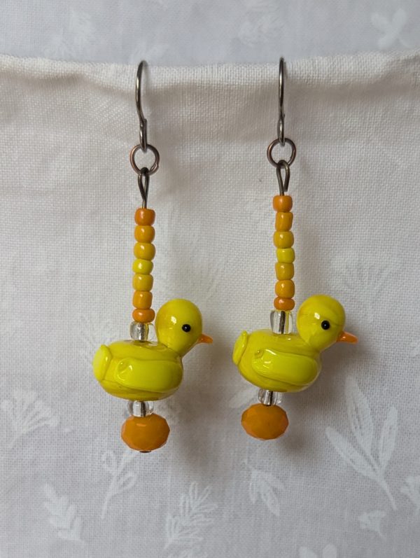 Handmade duck earrings with yellow glass duck beads, orange and yellow seed beads, Czech orange bead, and clear accents on titanium hooks.