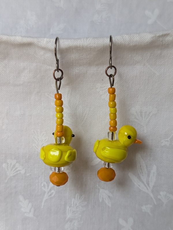 Handmade duck earrings with yellow glass duck beads, orange and yellow seed beads, Czech orange bead, and clear accents on titanium hooks.