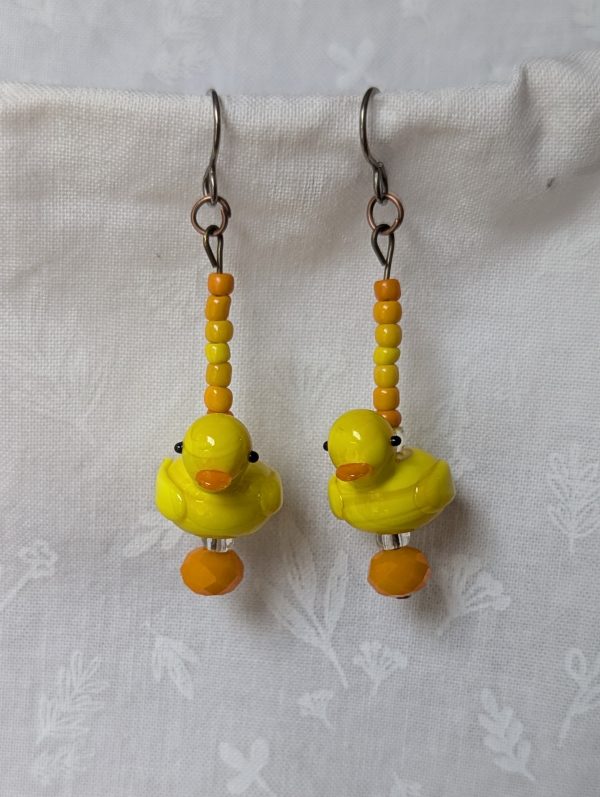 Handmade duck earrings with yellow glass duck beads, orange and yellow seed beads, Czech orange bead, and clear accents on titanium hooks.