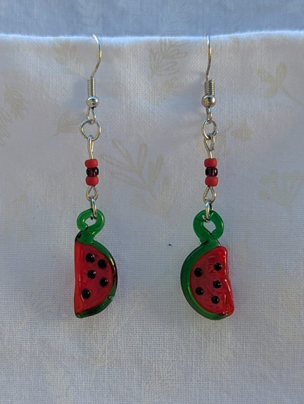 Handmade glass watermelon slice earrings with pink-red centers, green rinds, and sterling silver hooks.