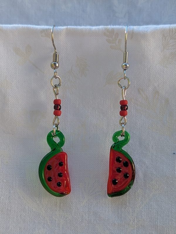 Handmade glass watermelon slice earrings with pink-red centers, green rinds, and sterling silver hooks.
