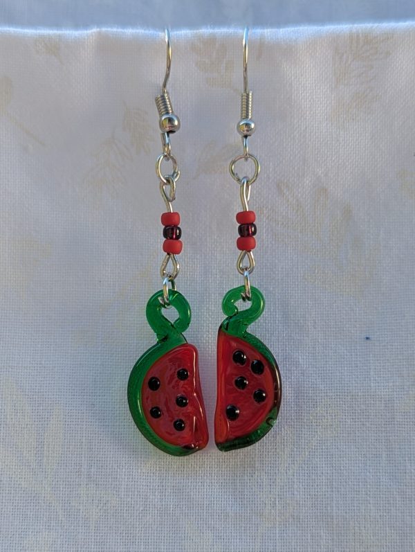 Handmade glass watermelon slice earrings with pink-red centers, green rinds, and sterling silver hooks.