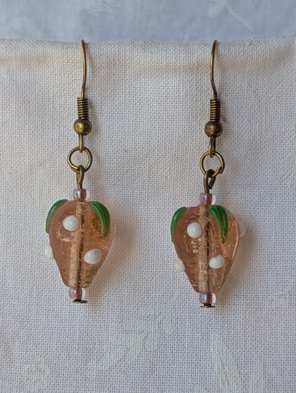 Handmade glass sweet strawberry earrings with pale pink, green, and white details on steel hooks
