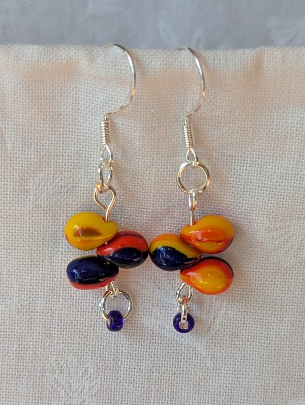 Handmade fireburst trio teardrop glass bead earrings featuring yellow, red, and blue teardrop beads on silver pins with sterling silver hooks.