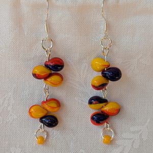 Handmade carnival-themed earrings with cascading yellow, red, and blue glass teardrop beads and a small yellow seed bead on sterling silver hooks.