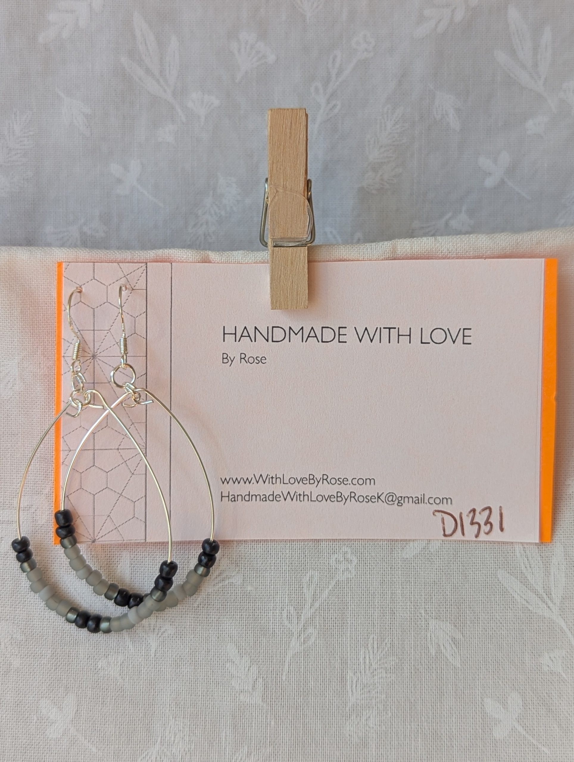 Handmade black and gray monochrome hoop beaded earrings featuring 20 glass beads on silver-plated wire and sterling silver hooks.