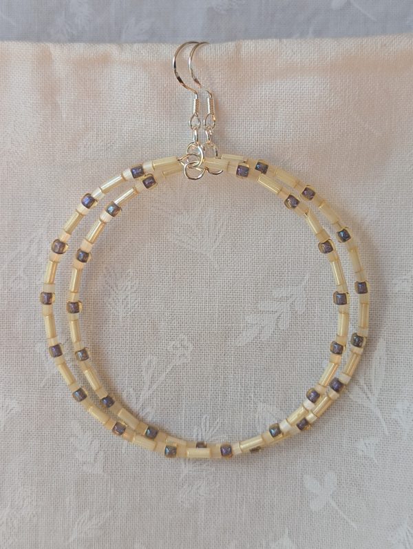 Handmade cream and lavender-gray beaded hoop earrings with glass beads on silver-plated memory wire and sterling silver hooks.