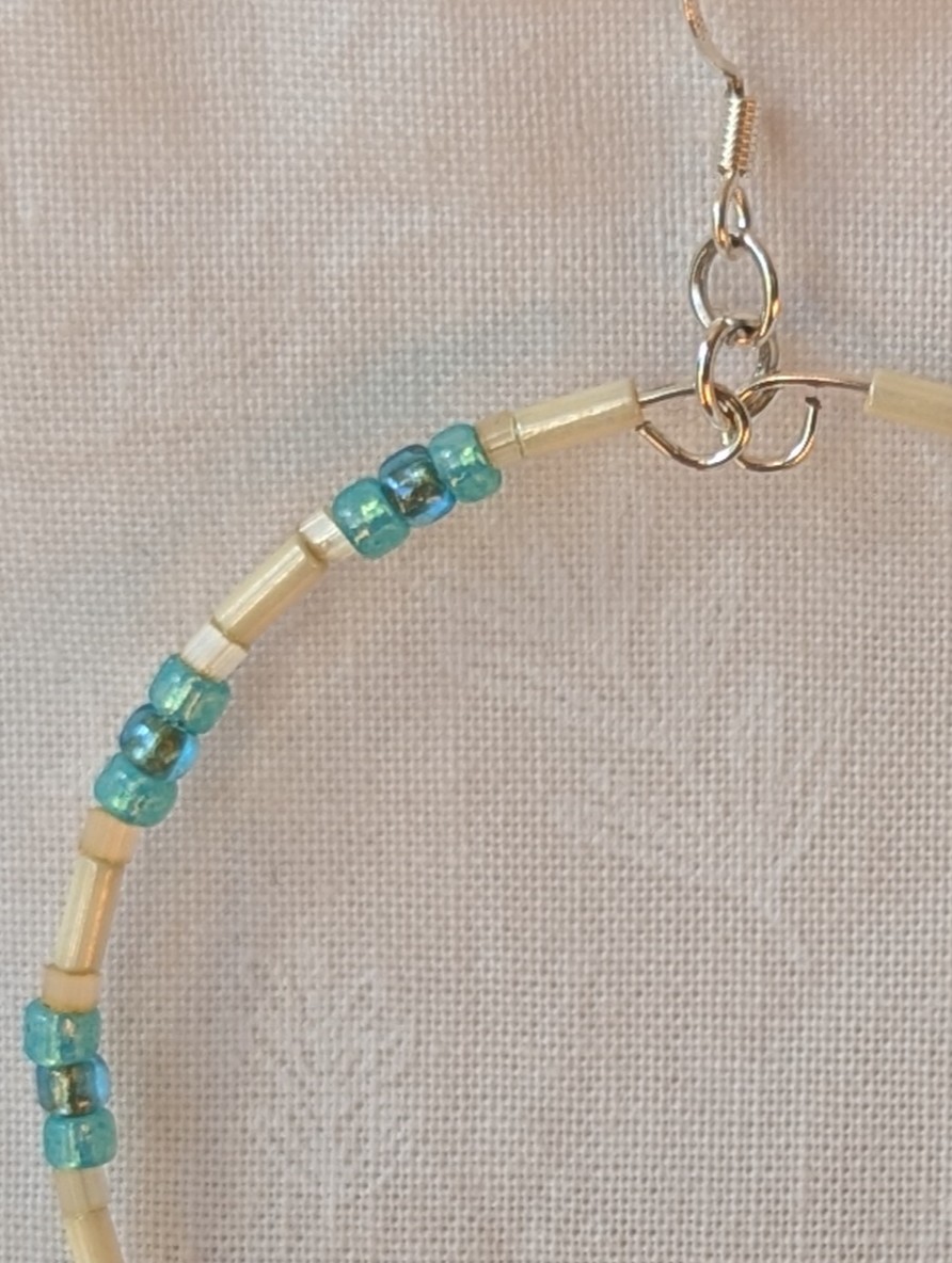 Handmade cream and sky blue beaded hoop earrings with glass beads on silver-plated memory wire and sterling silver hooks.
