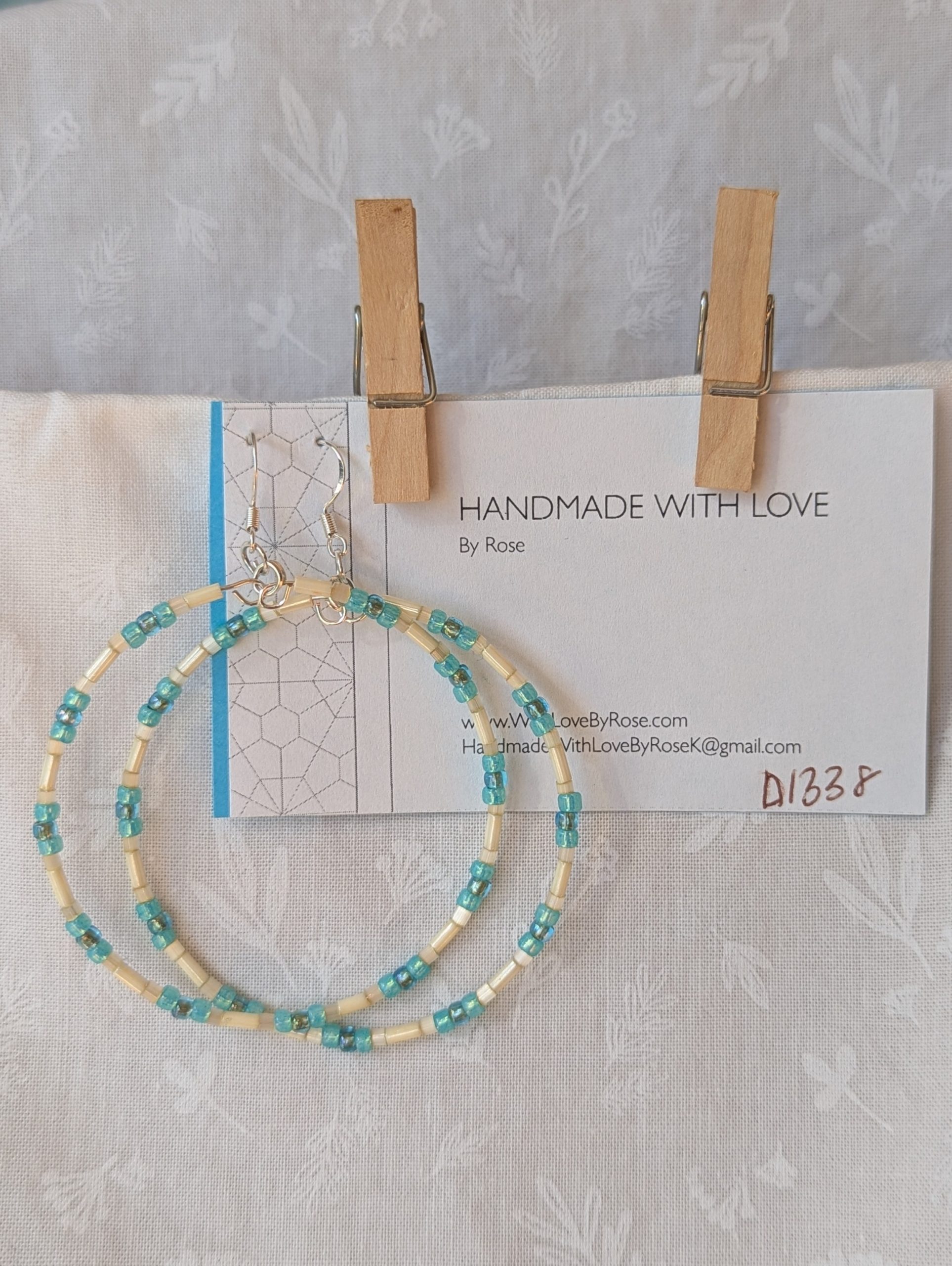 Handmade cream and sky blue beaded hoop earrings with glass beads on silver-plated memory wire and sterling silver hooks.