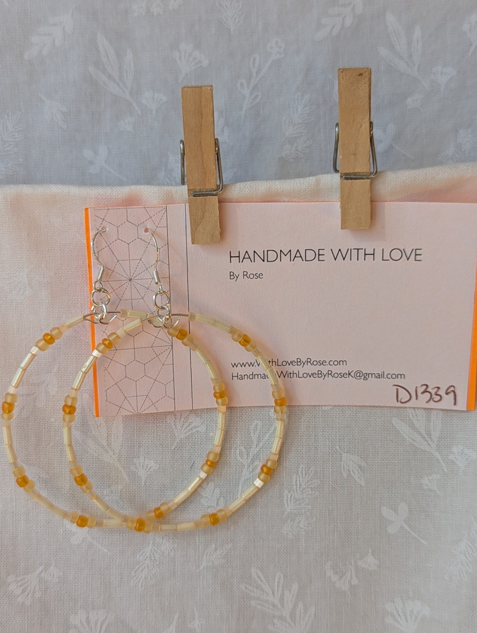 Handmade cream and sunshine yellow/orange beaded hoop earrings with glass beads on silver-plated memory wire and sterling silver hooks.