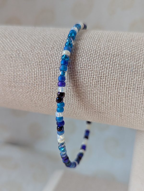 Handmade blue and white bracelet with mixed blue glass beads, white accent beads, and a silver lobster clasp.