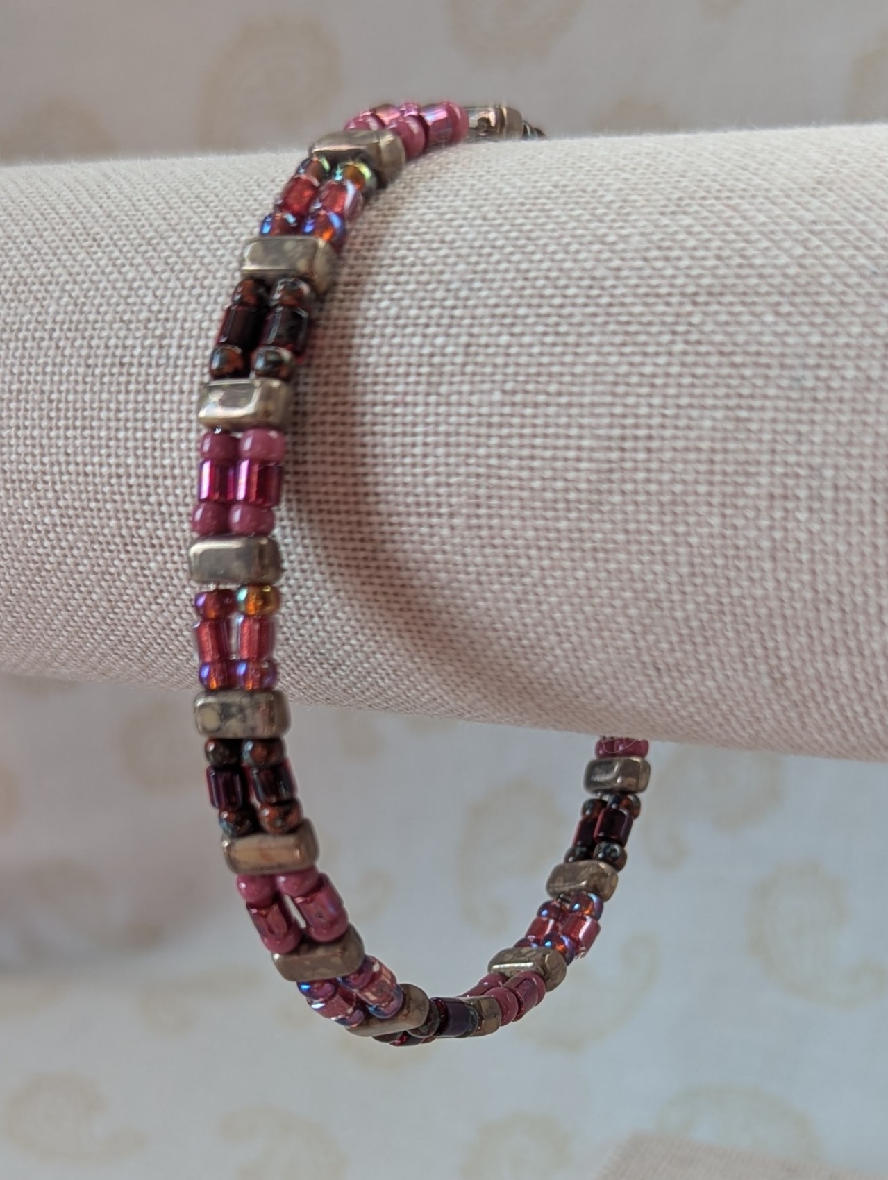 Double-strand memory wire bracelet with rose mauve, garnet, and taupe rectangular stone beads, finished with a silver lobster clasp.