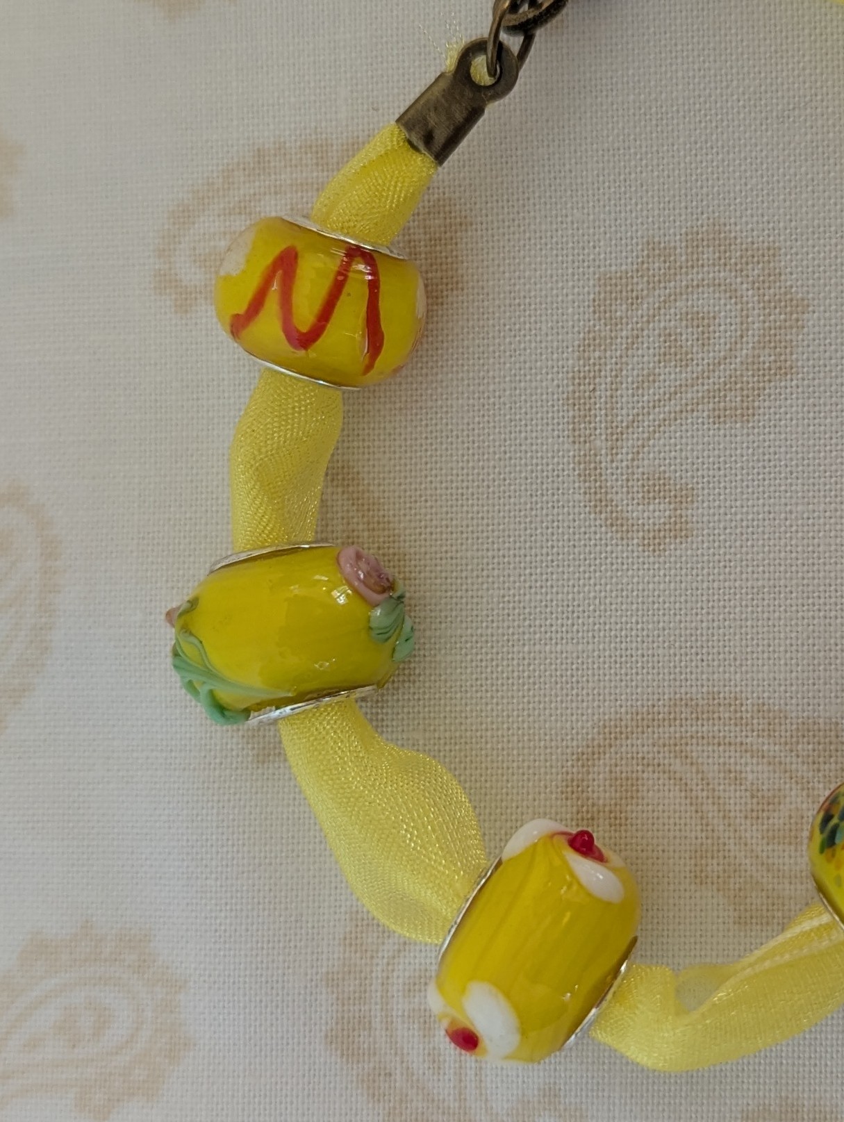 Sunshine Yellow Lampwork and Ribbon Bracelet: six yellow lampwork-style glass beads on a bright yellow ribbon with a lobster clasp closure