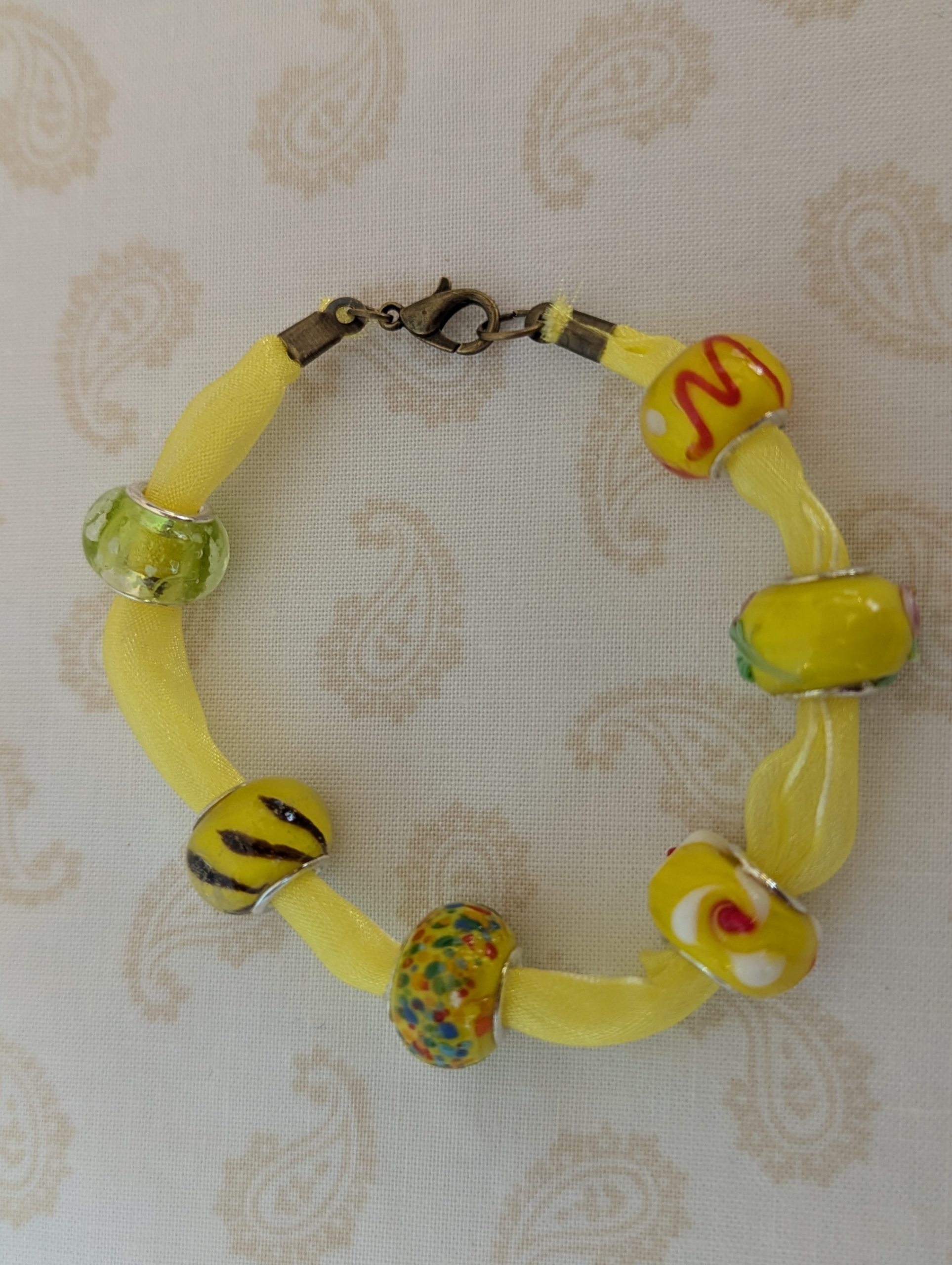 Sunshine Yellow Lampwork and Ribbon Bracelet: six yellow lampwork-style glass beads on a bright yellow ribbon with a lobster clasp closure