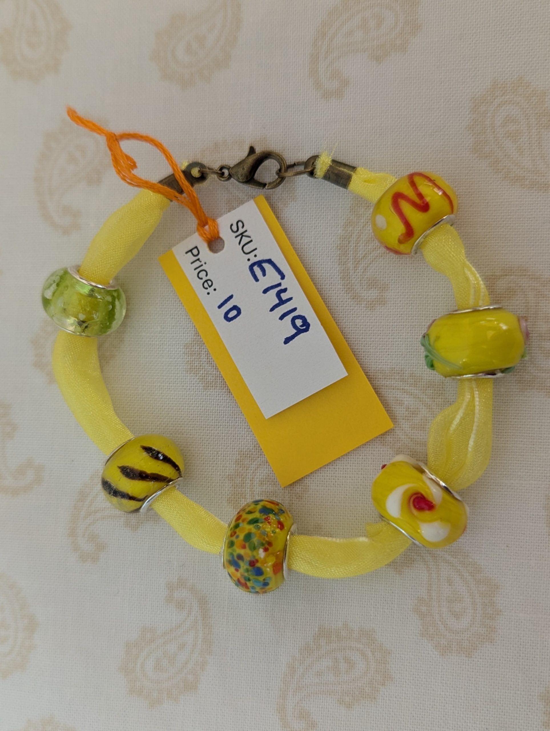 Sunshine Yellow Lampwork and Ribbon Bracelet: six yellow lampwork-style glass beads on a bright yellow ribbon with a lobster clasp closure
