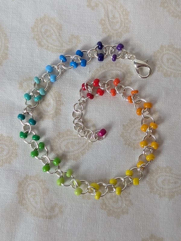 Rainbow seed bead bracelet with silver chain, paired glass seed beads in a red to purple gradient, and silver lobster clasp