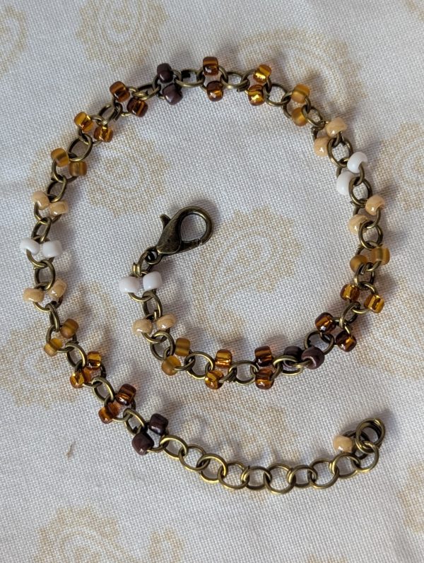 Brown seed bead bracelet with bronze chain, beige to mahogany gradient beads, and bronze lobster clasp