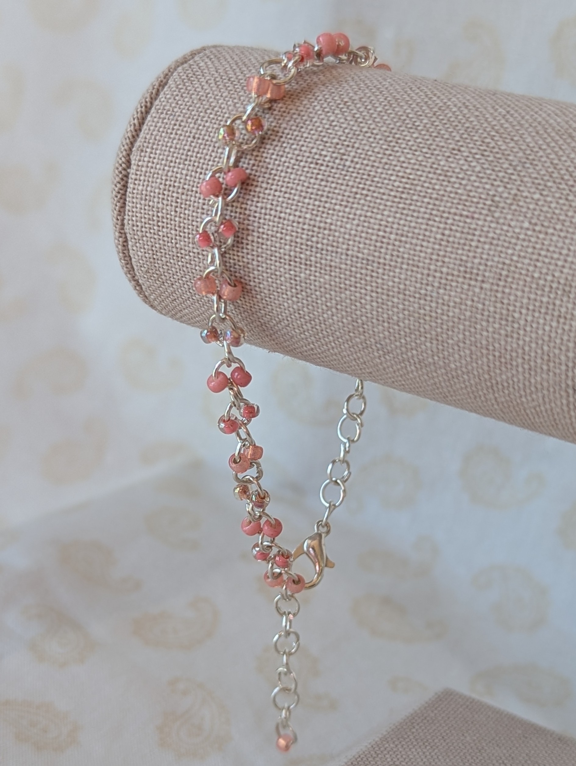 Blush and Petal Pink Beaded Chain Bracelet: a silver chain bracelet with pale pink seed beads in solid blush, pink-lined clear, and pearly iridescent finishes, secured with a lobster clasp.