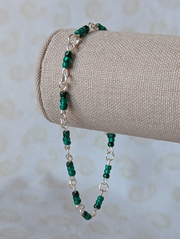 Handmade emerald green seed bead bracelet with silver chain links and forest green glass bead clusters.