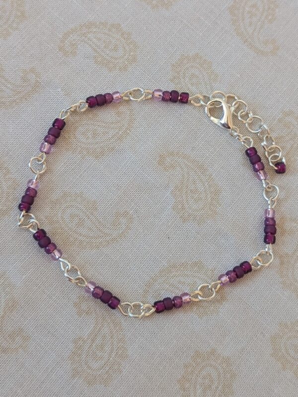 Silver-toned chain bracelet with gradient purple glass seed beads in lilac, lavender, and plum tones